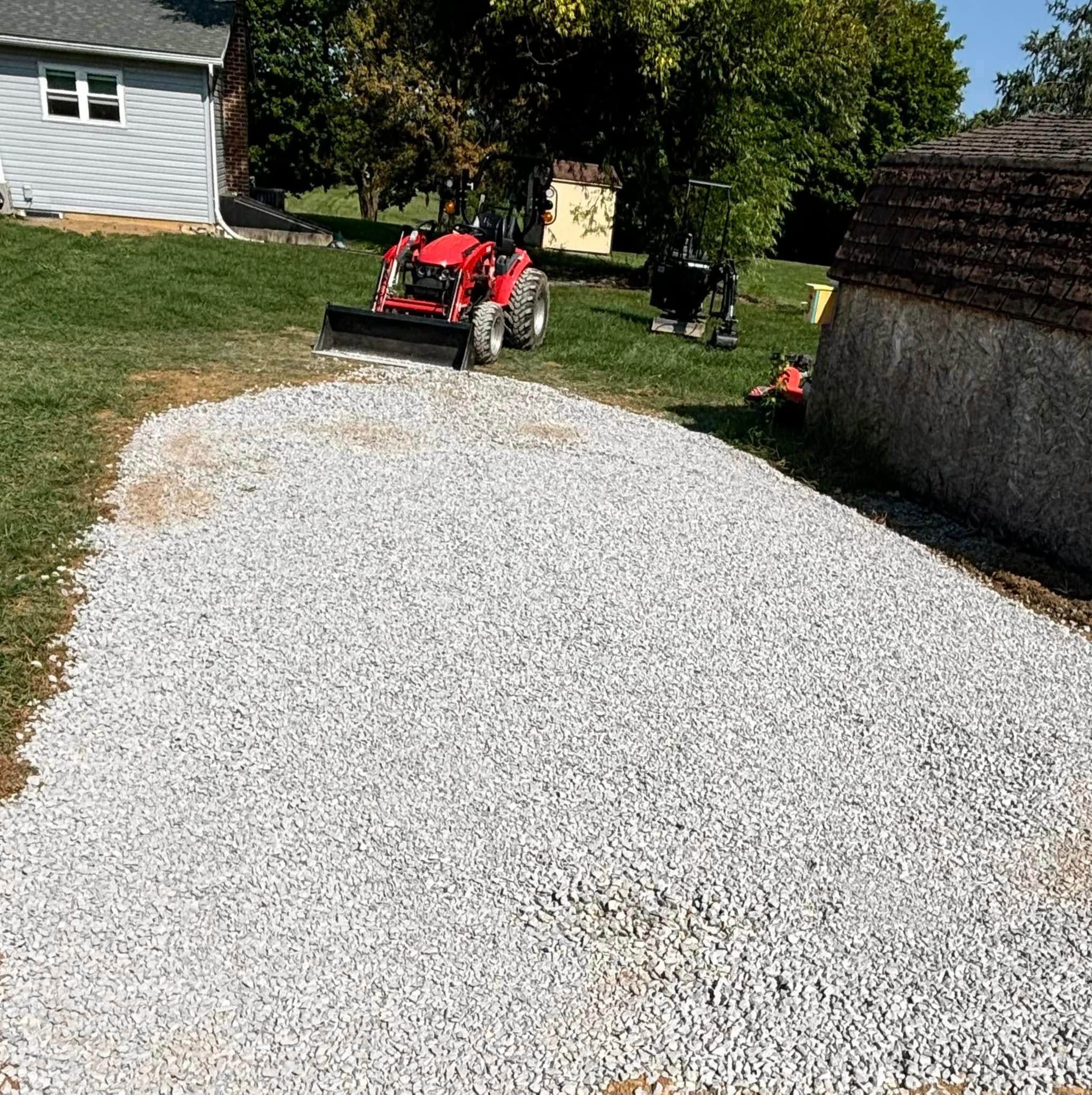 Tractor plowing snow from a long driveway